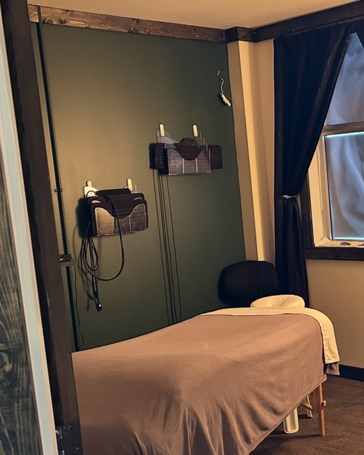 LED light therapy panels on the wall beside a massage table at TCH Massage in Olds