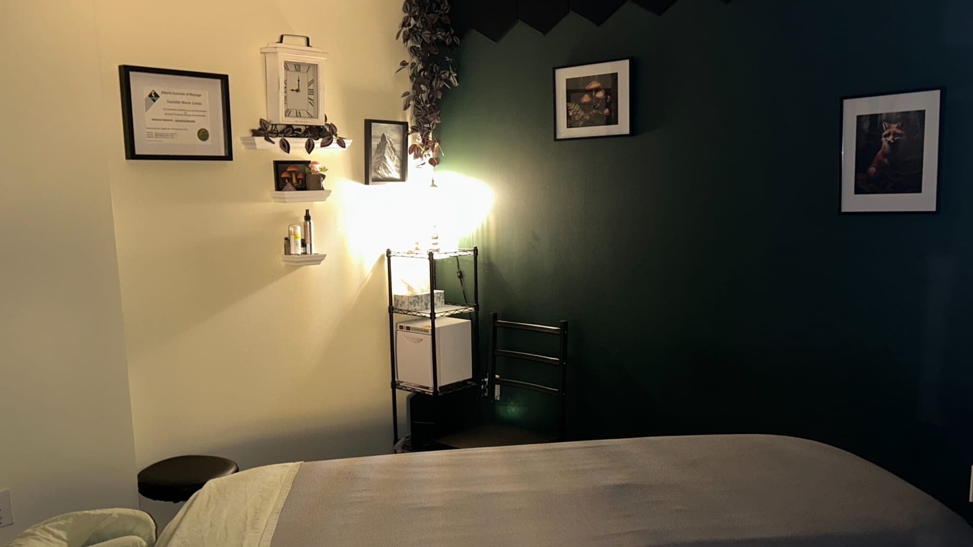 Massage table in a green-walled treatment room at TCH Massage in Olds